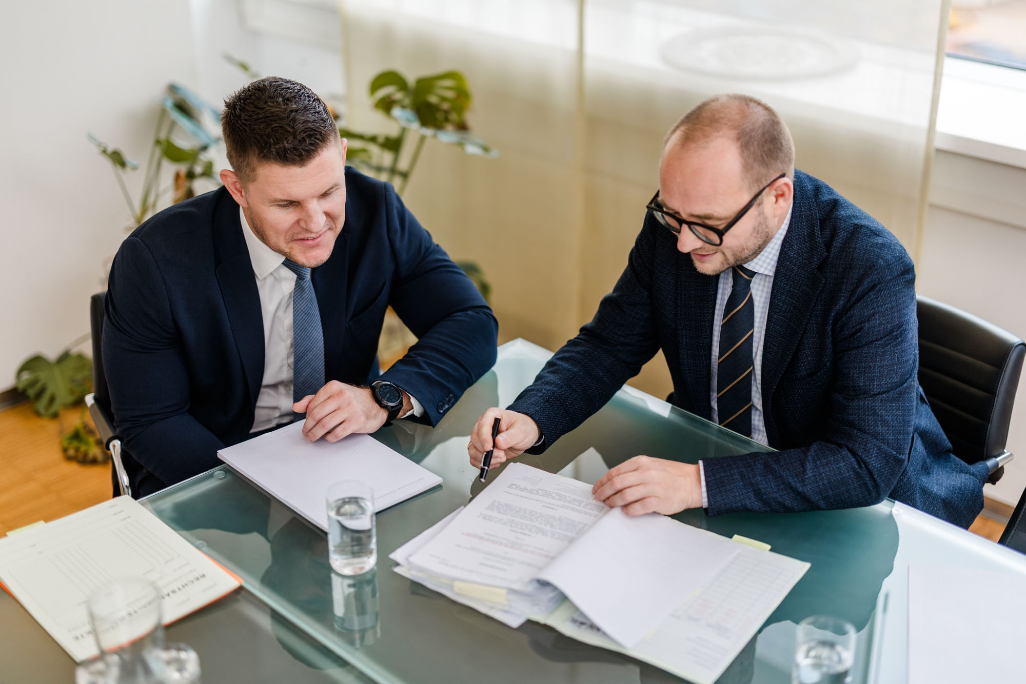 Zwei Anwälte arbeiten gemeinsam an Unterlagen auf einem Tisch