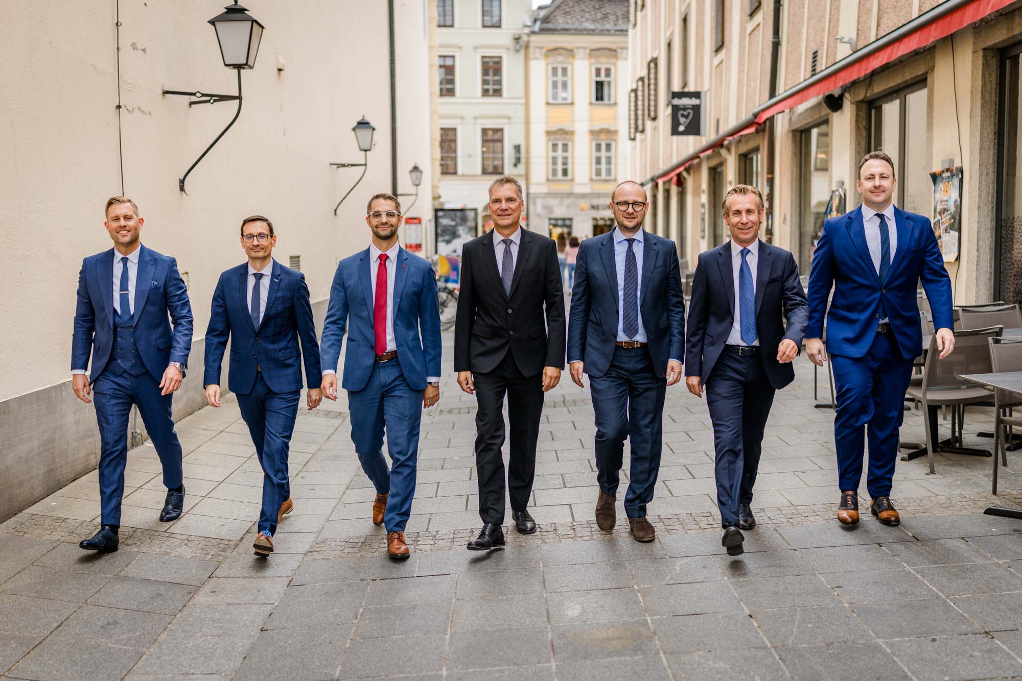 Teamfoto Rechtsanwälte gehen gemeinsam durch Straße in Linz